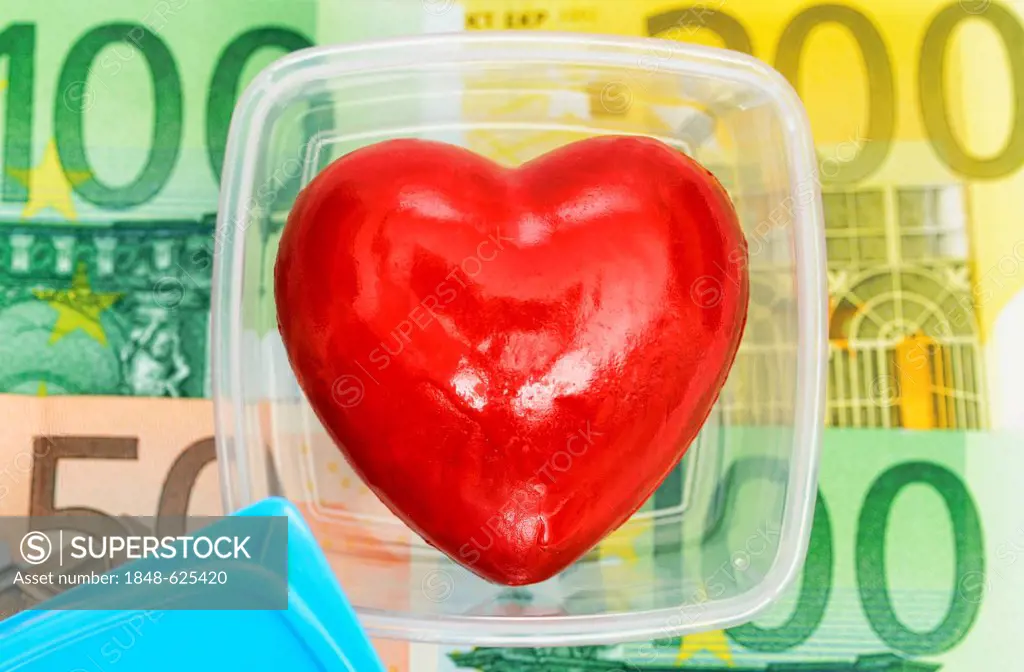 Heart in food storage container with bank notes, symbolic image organ trade