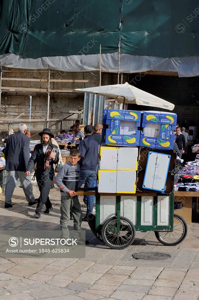 Palestinian boy pushing a typical trolley, cart suitable for the narrow alleyways in the Muslim Quarter in the Old City of Jerusalem, Israel, Western ...