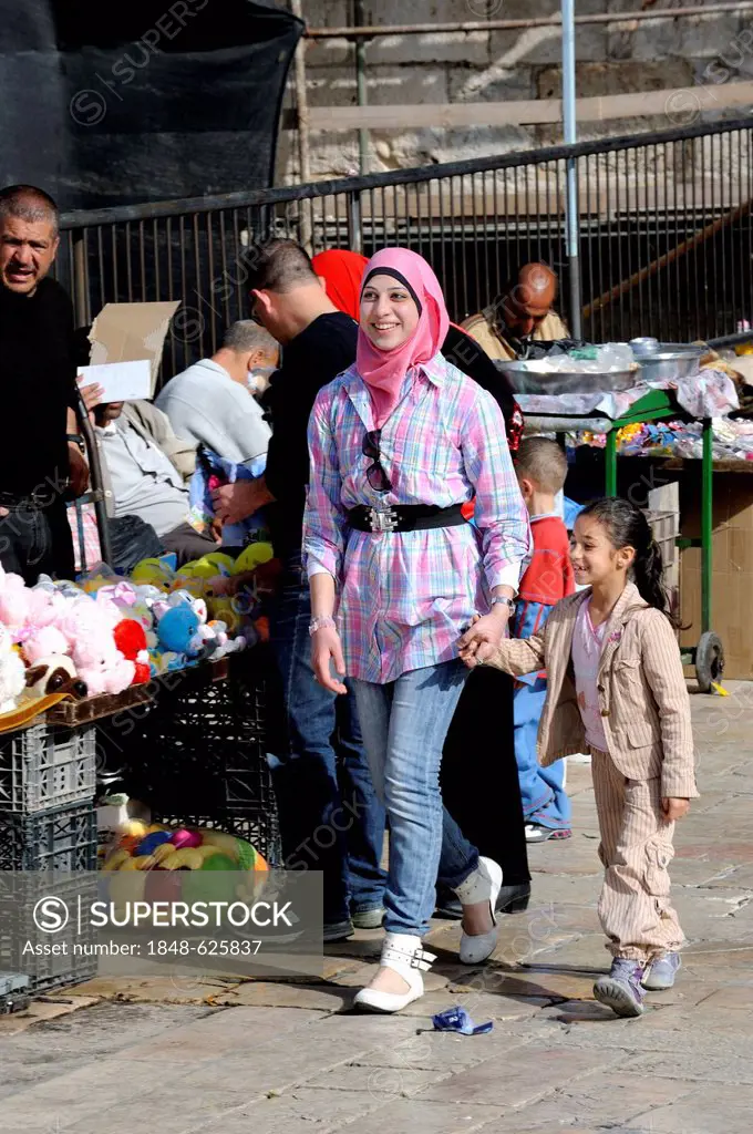 Palestinian woman with a headscarf and fashionable clothing, holding a girl by the hand at the Damascus Gate, Muslim Quarter, Jerusalem, Israel, Weste...