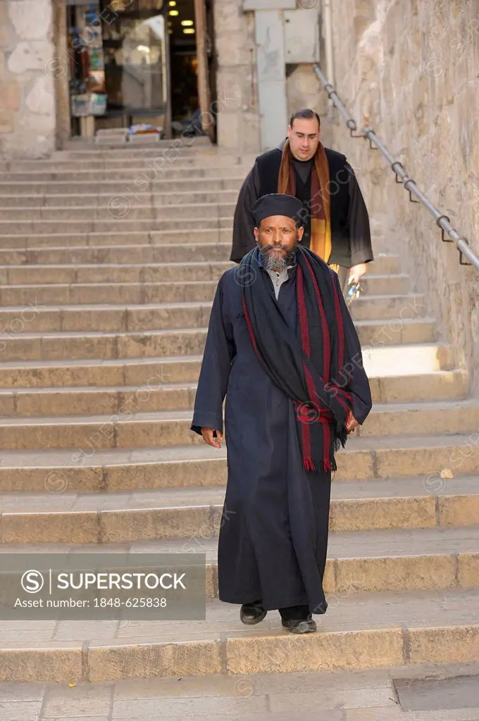 Priests of various denominations, Roman Catholic and Ethiopian Orthodox, walking down stairs towards the Church of the Holy Sepulchre, Christian Quart...