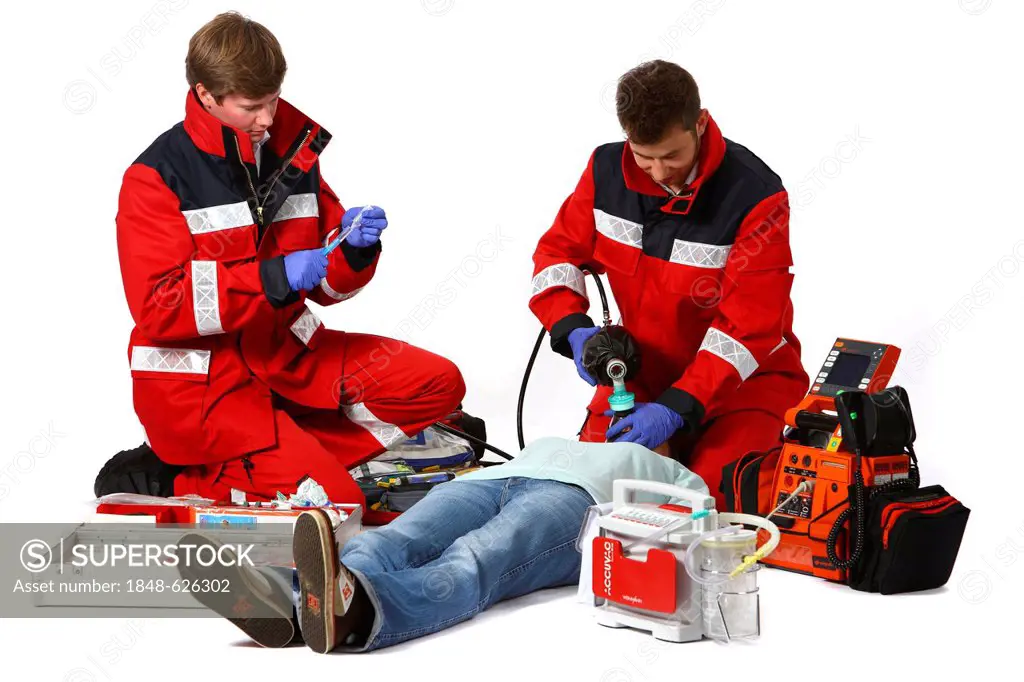 Paramedics with emergency equipment, a first aid kit with bandages, medication, a defibrillator, ECG, breathing apparatus, recuscitating a patient, pr...