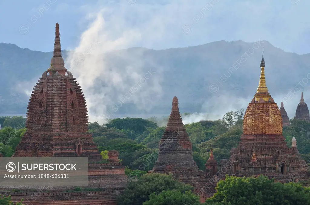 Smoke rising between the temples and pagodas in Bagan, Myanmar, Burma, Southeast Asia, Asia