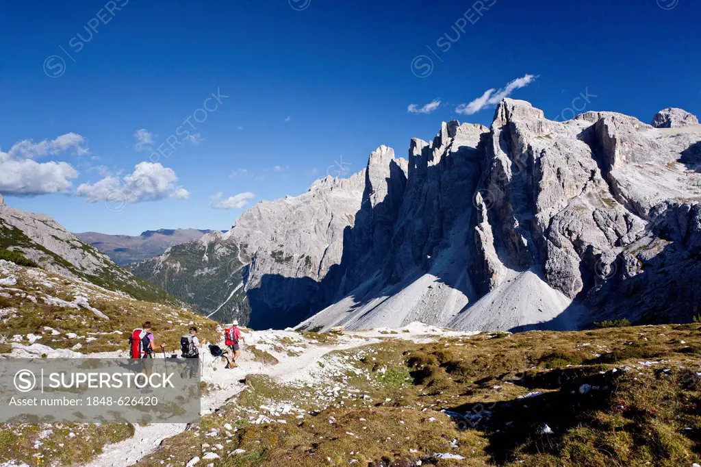 Hikers during the descent from Drei-Zinnen-Huette mountain cabin, Einser mountain at the back, Hochpustertal valley, Sexten, Dolomites, province of Bo...