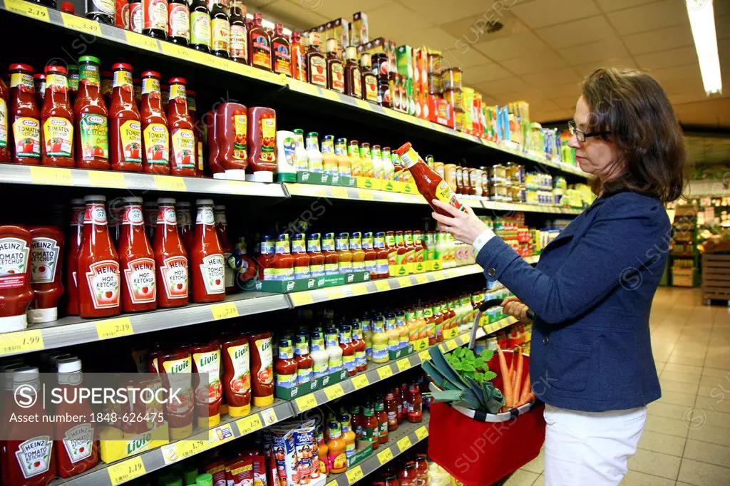 Woman shopping in a self-service grocery department, supermarket, Germany, Europe