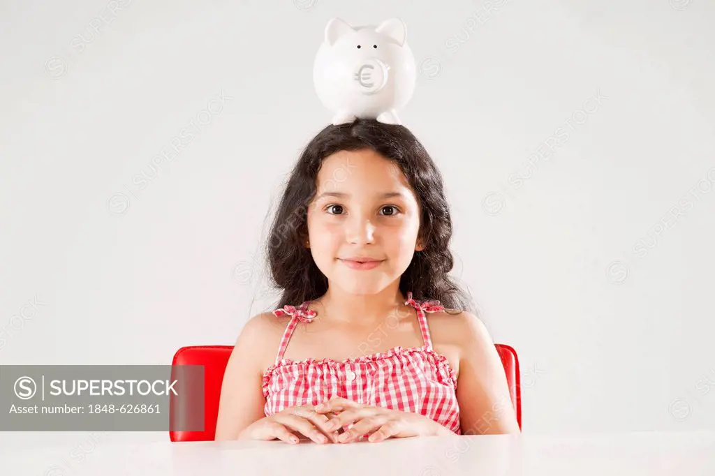 Girl with a piggy bank on her head