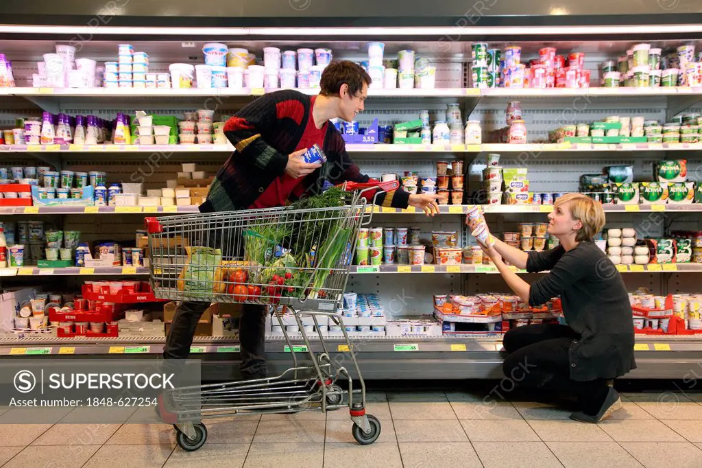 Customers standing in front of the refrigerated shelf, dairy products, food hall, supermarket, Germany, Europe
