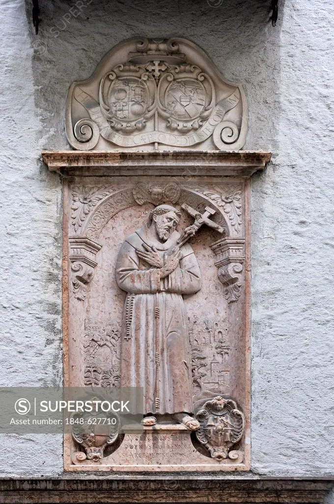 Relief of St Francis of Assisi, 1181-122, with inscription and the coat of arms of Wolf Dietrich von Raitenau on the wall of the Franciscan monastery ...