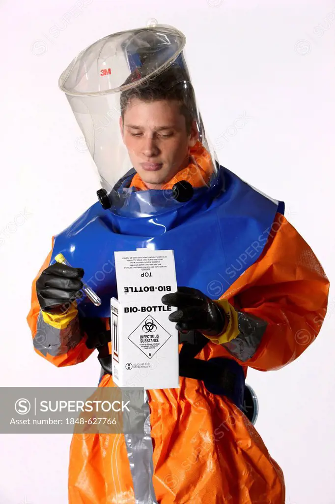 Firefighter wearing a protective suit for disease control holding a container for gathering samples, professional firefighter from the Berufsfeuerwehr...