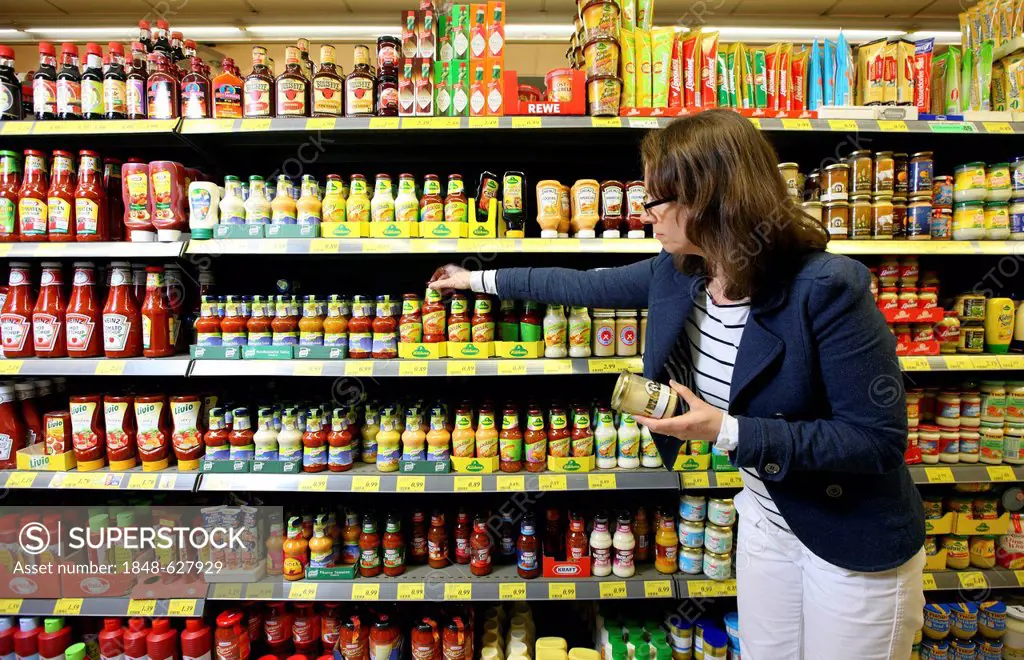 Woman shopping in a self-service grocery department, supermarket, Germany, Europe