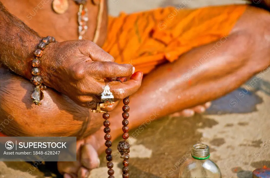 Sadhu, holy man, doing his washing and praying ceremony in the morning at the holy Narmada river, Omkareshwar, India, Asia