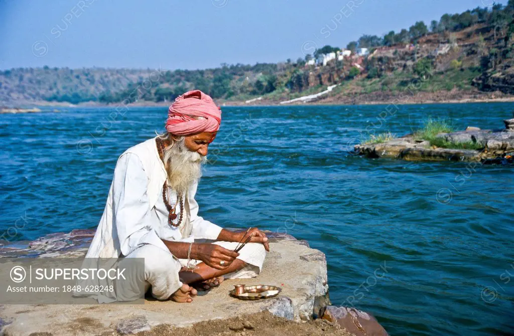 Pilgrim praying in the morning at the holy Narmada river, Omkareshwar, India, Asia