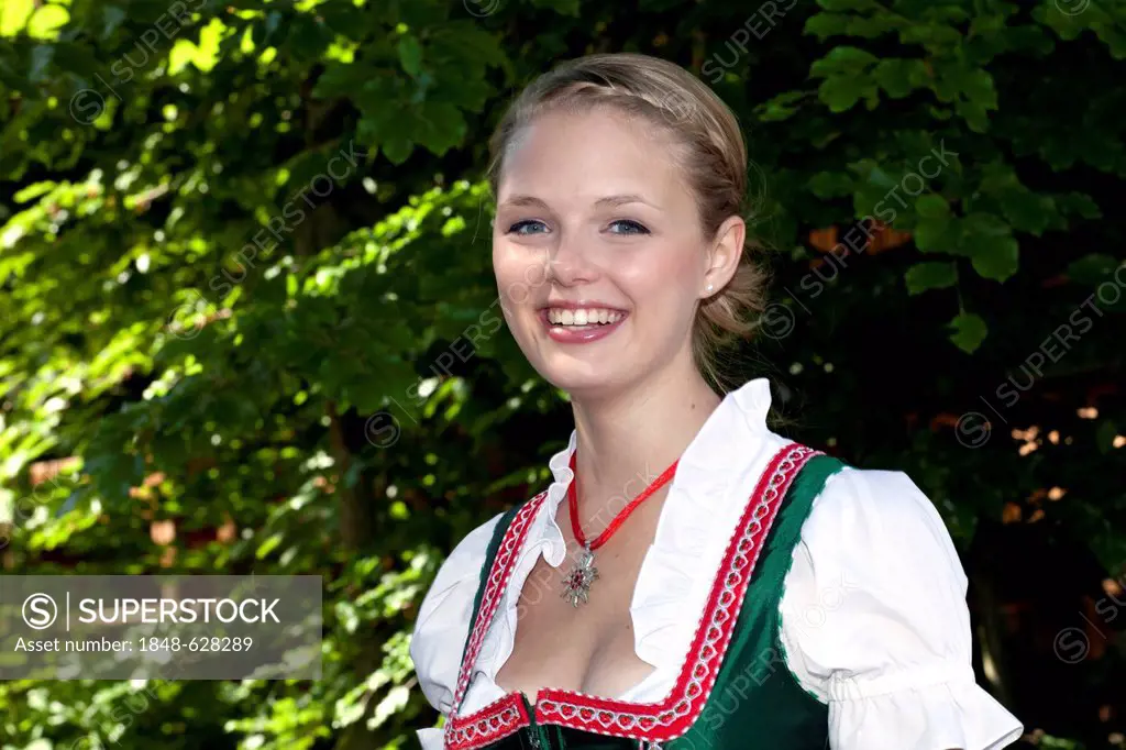 Young woman in a dirndl in a beer garden at Pettstatt, Upper Franconia, Bavaria, Germany, Europe