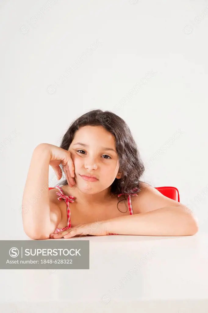 Girl sitting at a table, being bored