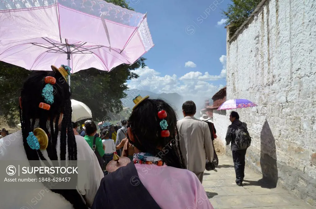 Tibetan Buddhism, Tibetan women with a traditional headdress and parasol at the revealing of the Buddha image, at the Shoton or Choedoen or Yoghurt Fe...