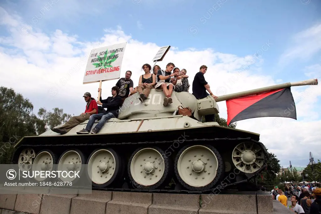 Participants of the Hemp Parade climb a tank at the Soviet War Memorial in Tiergarten, Strasse des 17. Juni, street, protest for the legalisation of c...