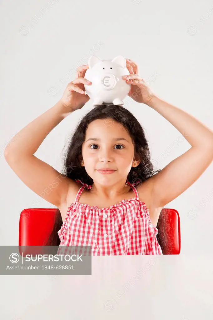 Girl holding a piggy bank on her head