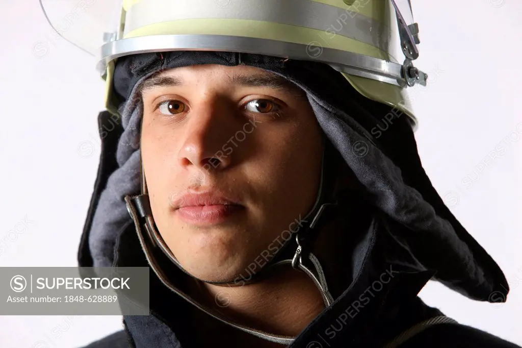 Firefighter wearing a uniform with basic equipment, protective clothing made of Nomex, a helmet with a visor, professional firefighter from the Berufs...