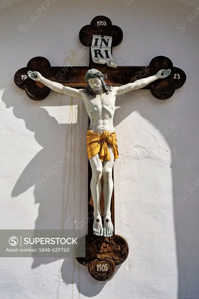 Christ on the Cross on the facade of the parish church of St. John the Baptist, Pfaffenhofen, Upper Bavaria, Bavaria, Germany, Europe