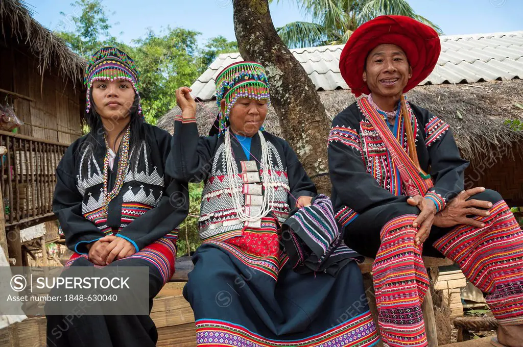 Traditionally dressed man and two women from the Black Hmong hill tribe, ethnic minority from East Asia, doing needlework, embroidery, Northern Thaila...