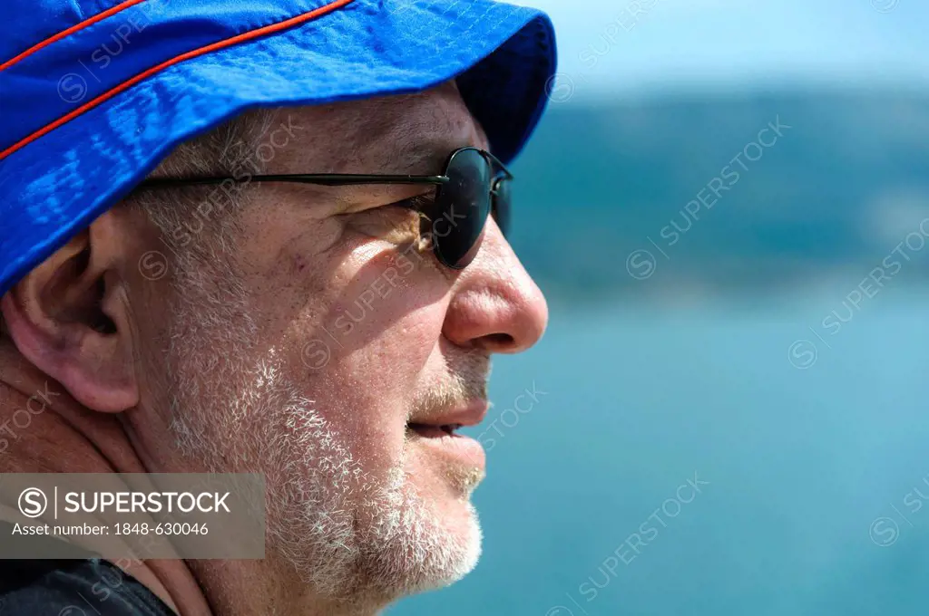 Old man wearing a blue hat and sunglasses, portrait