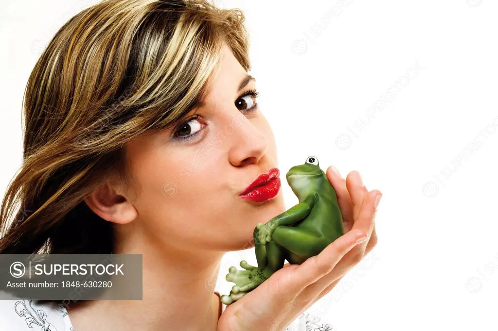 Young woman kissing a green frog in her hand