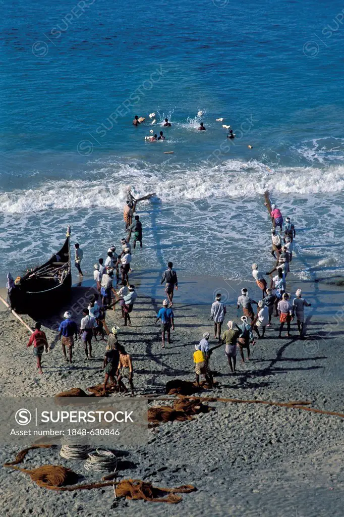 Fishermen pulling in their nets, beach, Kovalam, Kerala, South India, India, Asia