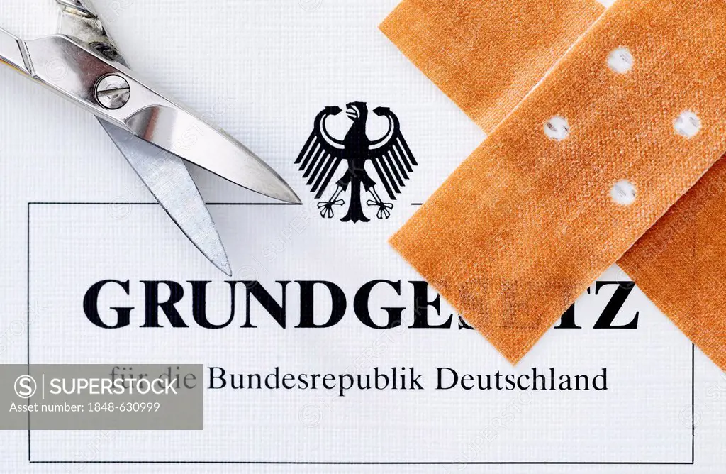 German Basic Law covered with a band-aid and scissors, symbolic image for circumcision and the German law