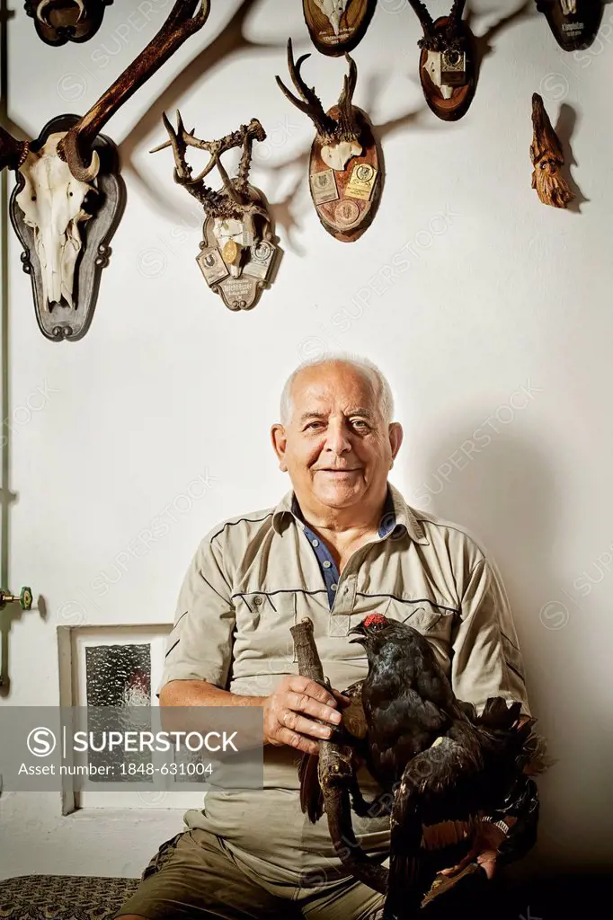 Old man with his collection of hunting trophies