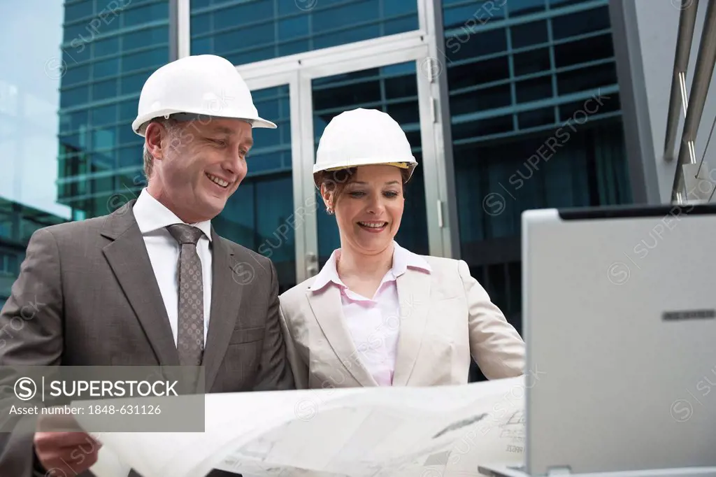 A male and a female architect checking a construction plan
