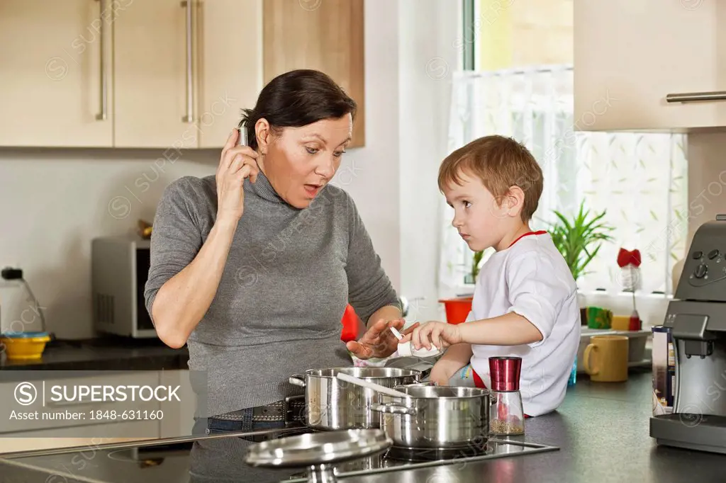 Woman cooking and boy behaving mischievously