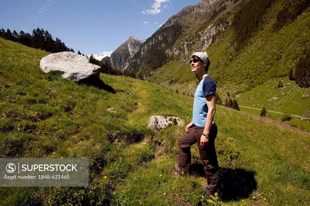 Young woman hiking, meadows, mountains behind, near Goeschenen, Goescheneralpsee, Reusstal, Reuss valley, Canton of Uri, Switzerland, Europe