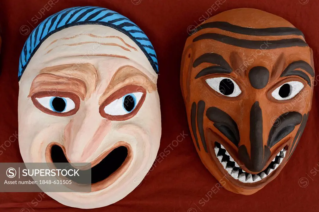 Two grotesque faces, Roman theatre masks made of clay, painted, replicas