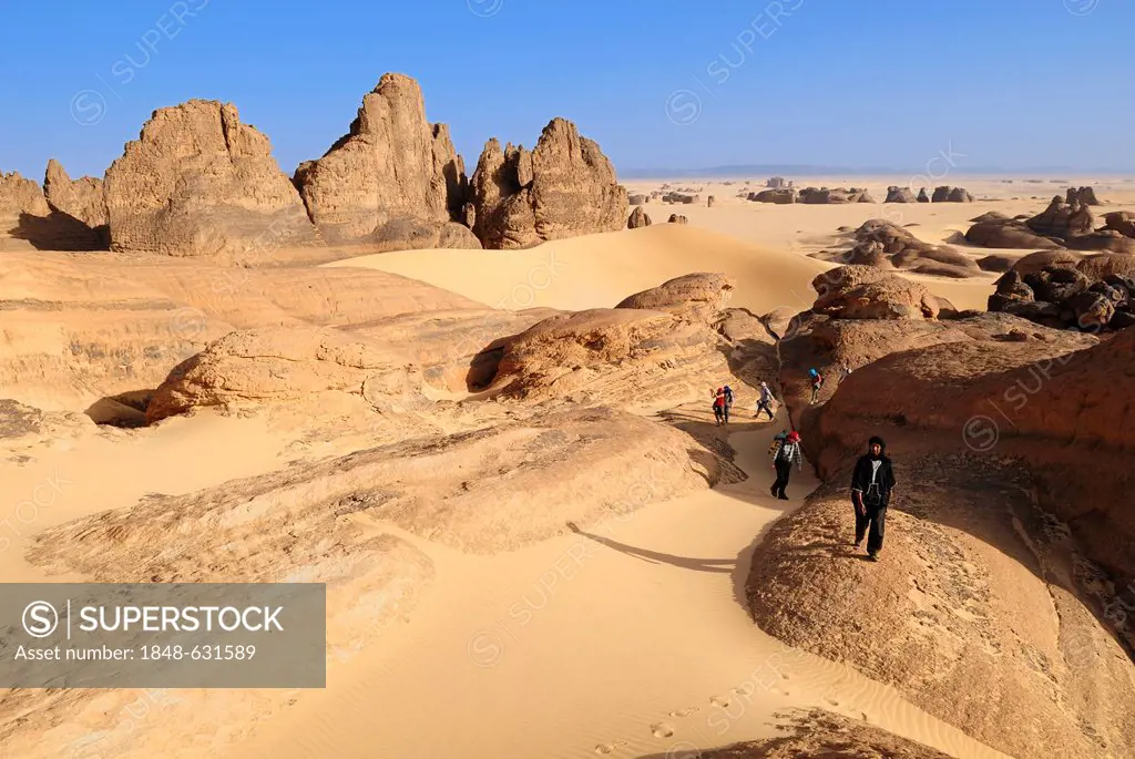 Group of tourists, hikers in the sandstone rock formation of Tin Akachaker, Tassili du Hoggar, Wilaya Tamanrasset, Algeria, Sahara desert, North Afric...