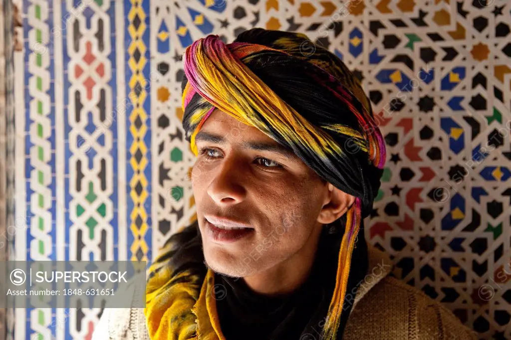 Young Berber man in front of a Zellij mosaic made of terracotta tiles, Telouet Kasbah, Telouet, Ounila Valley, High Atlas Mountains, Morocco, Africa