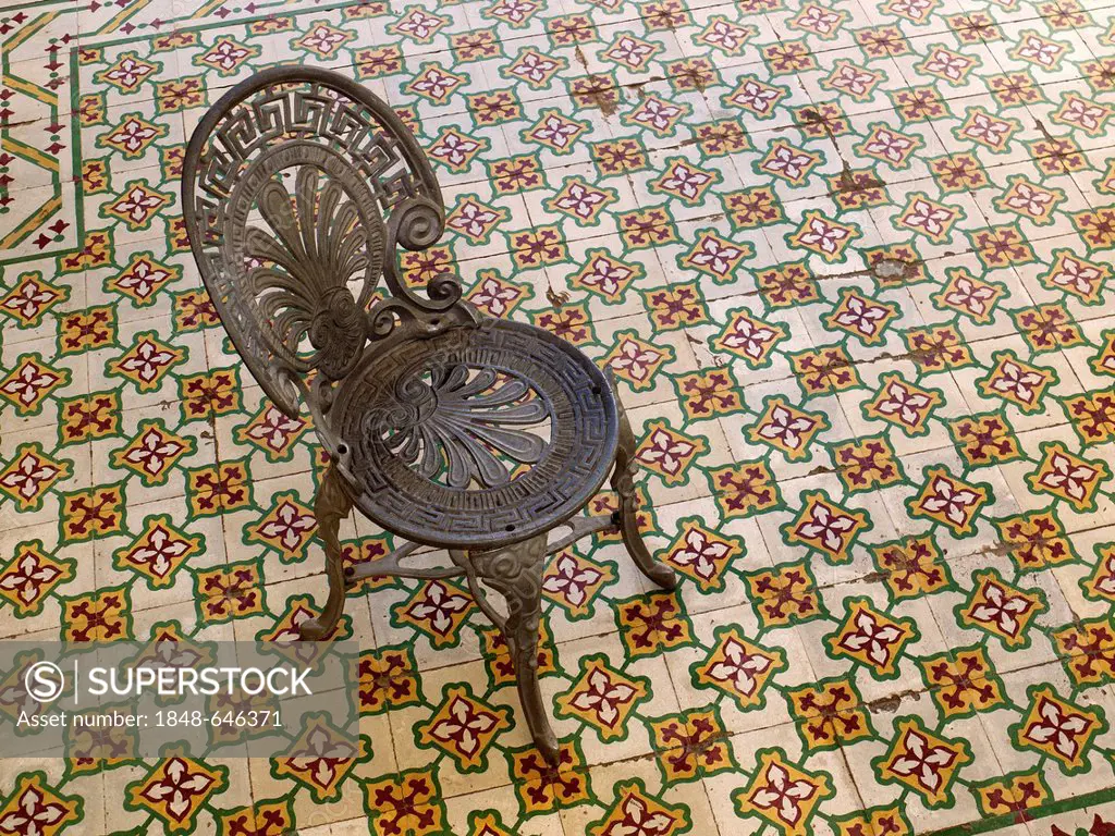 Antique iron chair standing on mosaic tile floor, Trinidad, Cuba, Latin America