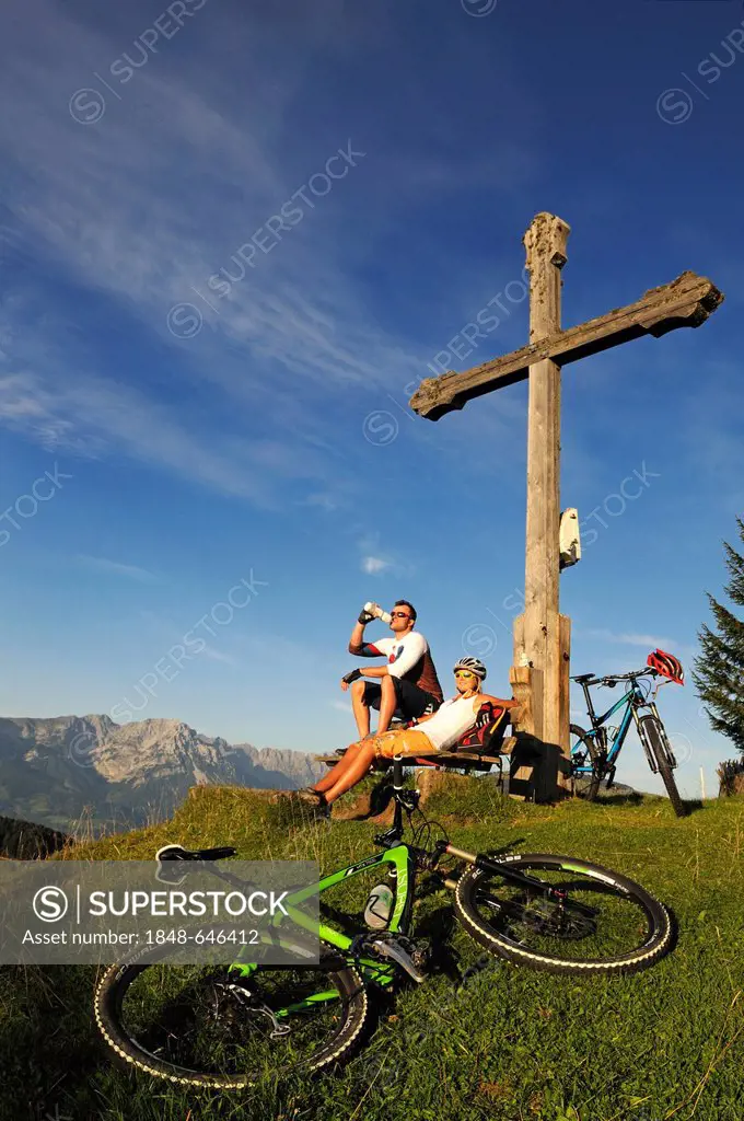 Mountain bikers resting at the Kraftalm alp, Wilder Kaiser massif at back, Mt Hohe Salve, Kitzbuehel Alps, Tyrol, Austria, Europe