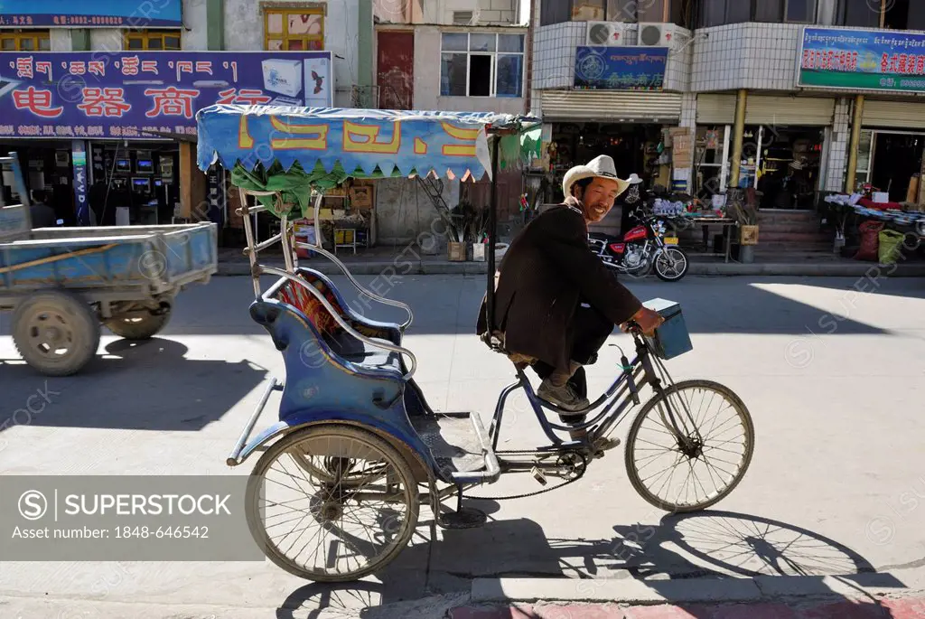 Rickshaw driver in the historic town centre of Shigatse, Tibet, China, Asia