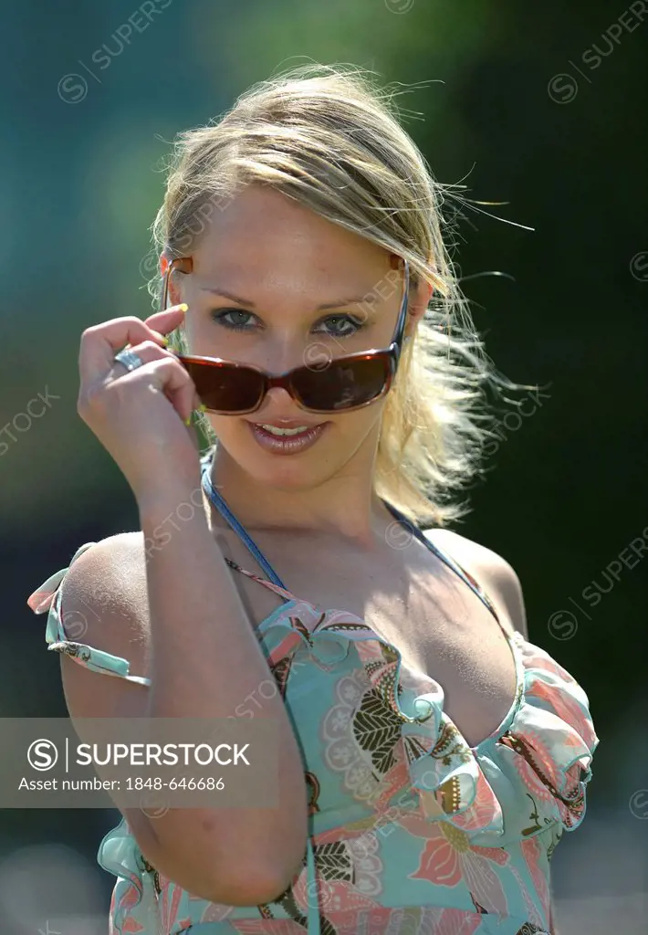 Young woman looking over the top of her sunglasses, Schlosspark, castle park, Stuttgart, Baden-Wuerttemberg, Germany, Europe, PublicGround