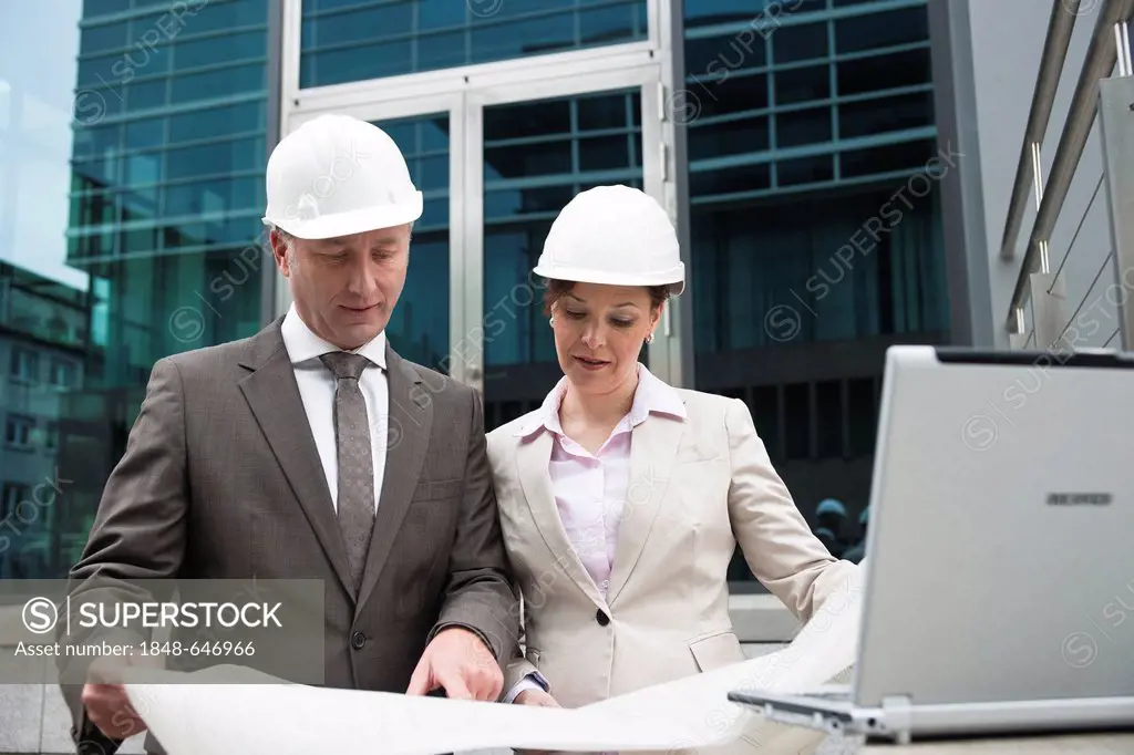 A male and a female architect checking a construction plan