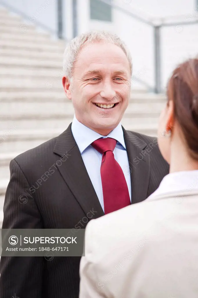 Businessman and businesswoman together in front of an office building