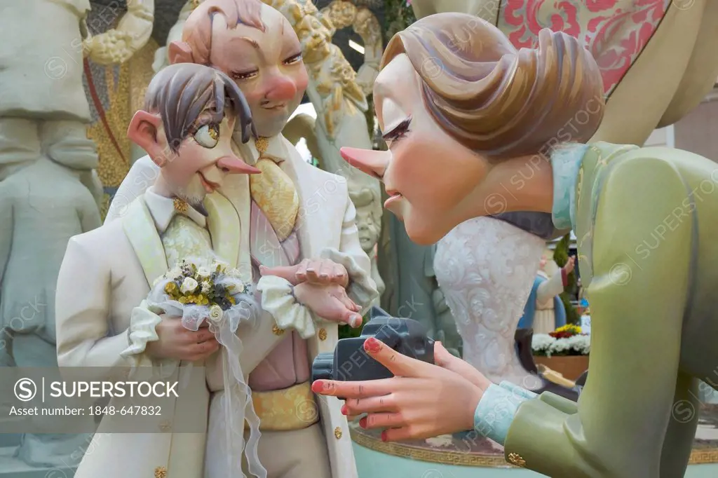 Crude carnival characters and satirical sculptures, woman filming a gay wedding, Fallas festival, Falles festival in Valencia in early spring, Spain, ...