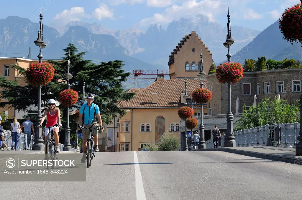 Couple riding electric bicycles in Bolzano, province of Bolzano-Bozen, Italy, Europe