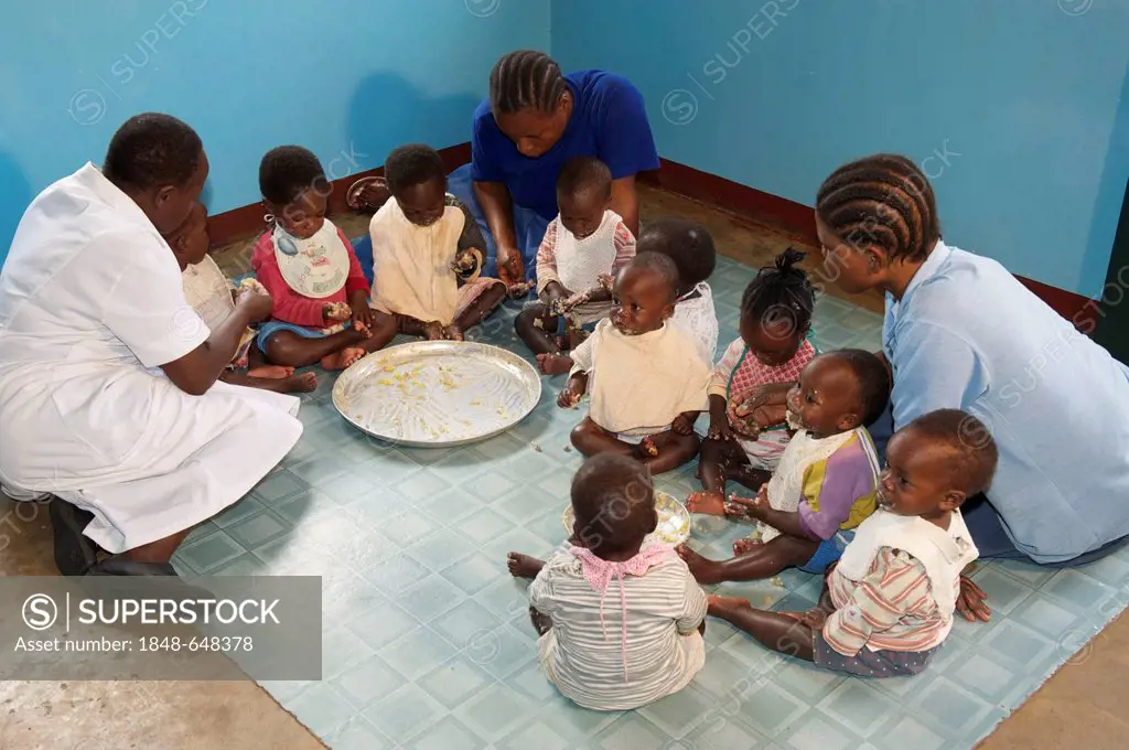 Infants eating with children's nurses in an orphanage near Bukoba, Tanzania, Africa