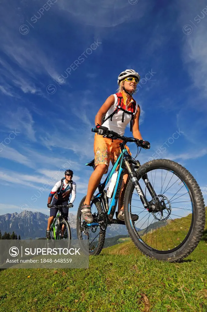 Mountain bikers at the Kraftalm alp, Wilder Kaiser massif at back, Mt Hohe Salve, Kitzbuehel Alps, Tyrol, Austria, Europe