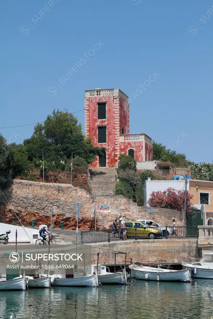 Building with a red facade in the port of Ciutadella, Menorca, Spain, Europe