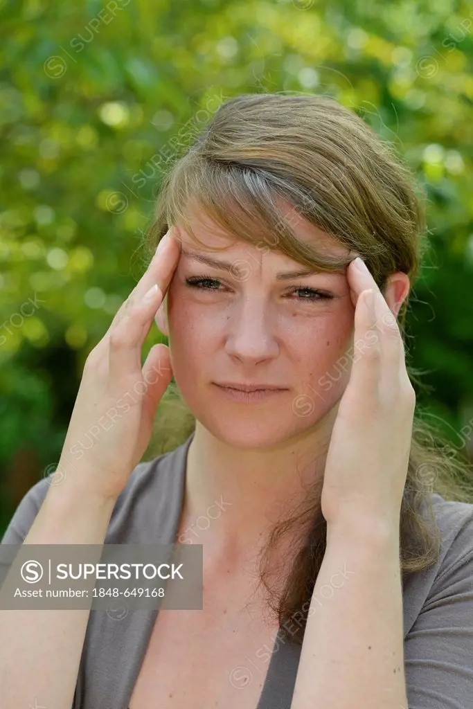 Woman with a headache holding her hands to her head