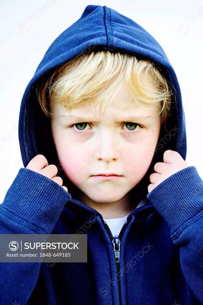 Grim faced 5-year-old boy wearing a hoodie jacket, portrait