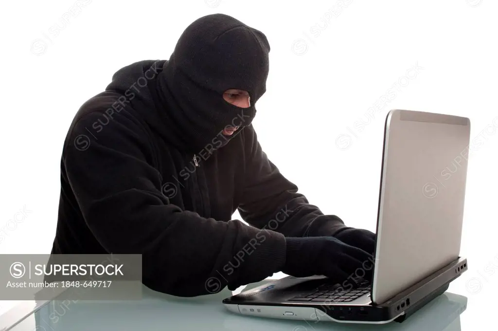 Hacker surfing the internet with a laptop computer, symbolic image for computer hacking, computer or cyber crime, data theft