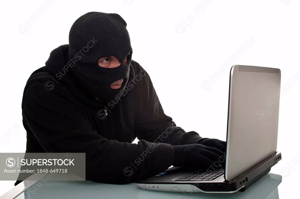 Hacker surfing the internet with a laptop computer, symbolic image for computer hacking, computer or cyber crime, data theft