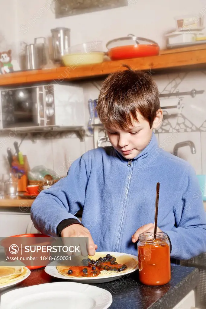 Boy making Palatschinken, pancakes